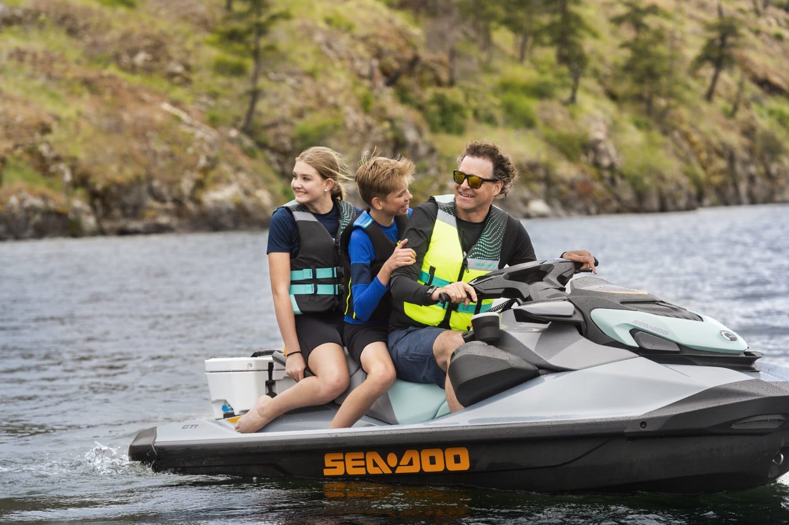 Fornøyde personer på en Sea-Doo jet-ski i vakker norsk natur, ideell for ATV og fritidseventyr, familieferie og vannaktiviteter.