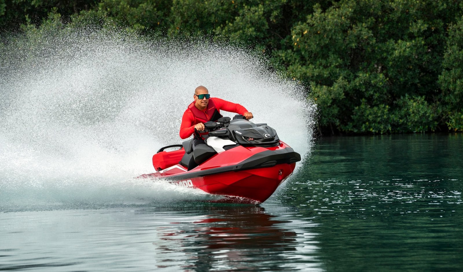 Høyfarts ATV på vann med rytter i rød jakke, vannskuter, fritidskjøretøy, utendørs eventyr.