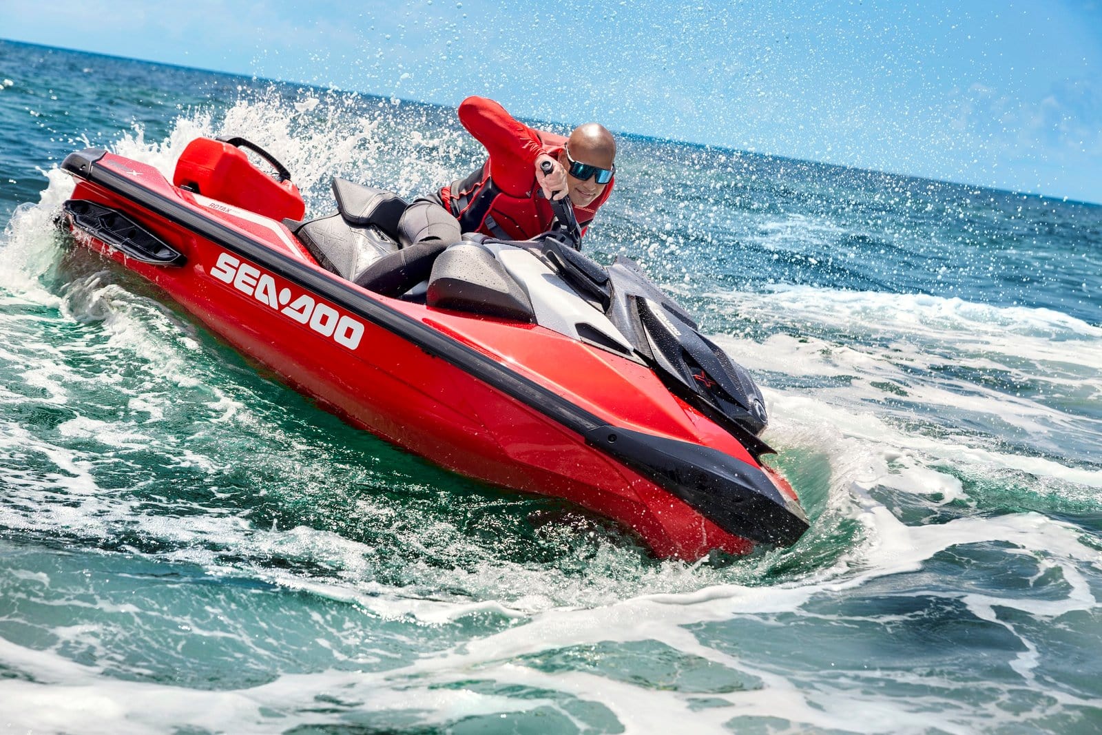 Yamahas RXT-X Jet Ski kjører gjennom havet med en person i rødt livsstøtteutstyr, omgitt av vannsprut, perfekt for vann- og fritidsaktiviteter.