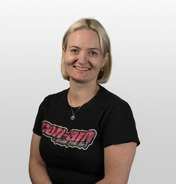 ATV og fritid, kvinne i svart T-skjorte med logo, smilende, med sikkerhetsutstyr, utendørs, eventyr, motor, friluftsliv, action, rekreasjon, sport, teknisk utstyr.